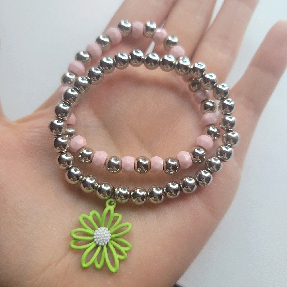 2 Silver bracelets, one with a green flower charm